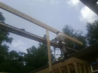 Carpenter setting a ridge beam over a new addition frame — Ice Dam Removal by Roofing Brothers in Jordan Valley