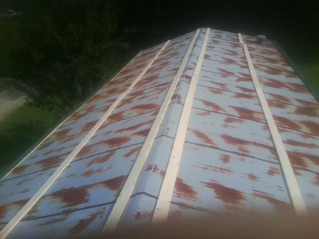 Rusted metal roof panels with new wood purlins before replacement — Storm Damage Roof Repair in Jordan Valley by Roofing Brothers