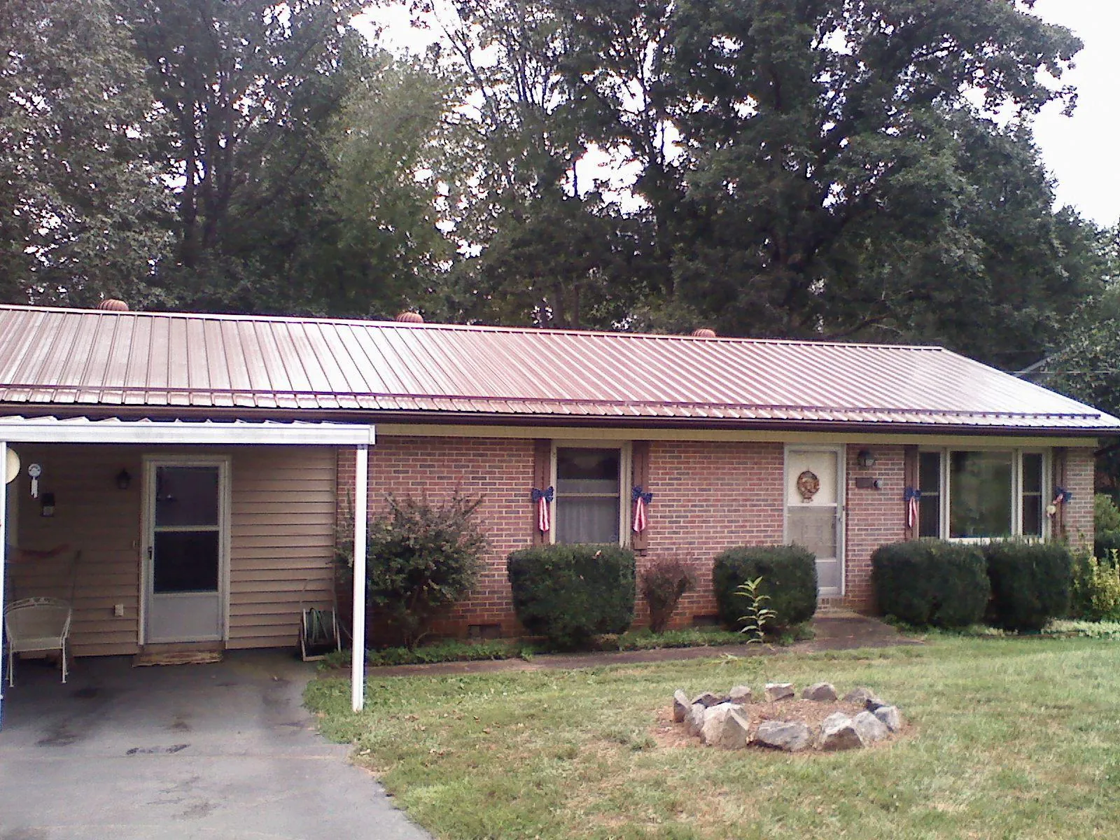 Bronze metal roof and carport on a brick ranch home — Roof Repair work by our crew in Jordan Valley